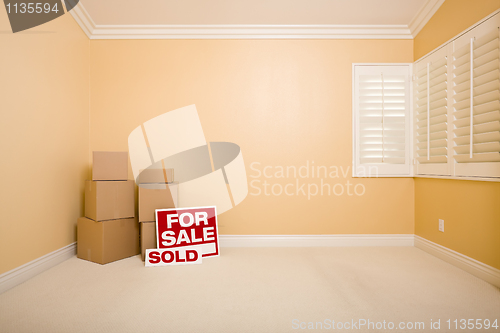 Image of Boxes, Sale and Sold Real Estate Signs in Empty Room