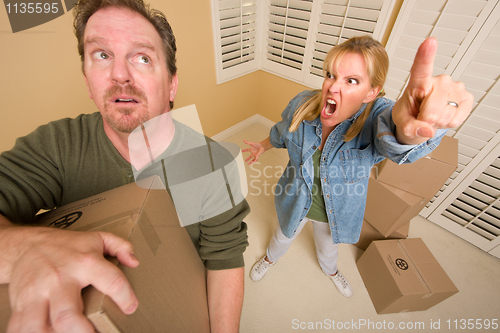 Image of Stressed Man Moving Boxes for Demanding Wife