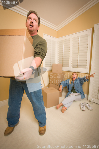 Image of Stressed Man Moving Boxes for Demanding Wife