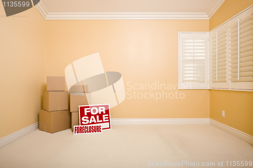 Image of Boxes, Sale and Foreclosure Real Estate Signs in Empty Room