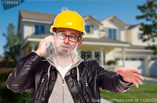 Image of Contractor Wearing Hard Hat on Phone In Front of House