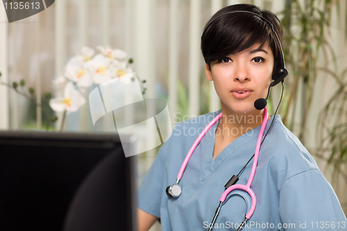 Image of Attractive Multi-ethnic Woman Wearing Headset, Scrubs and Stetho