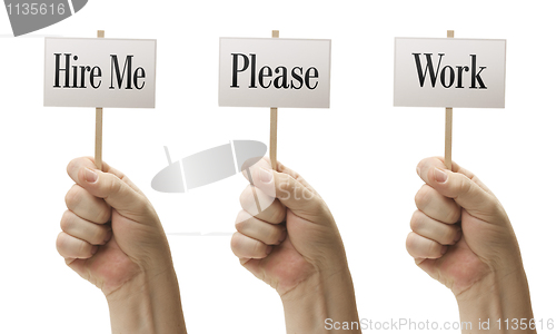 Image of Three Signs In Fists Saying Hire Me, Please and Work