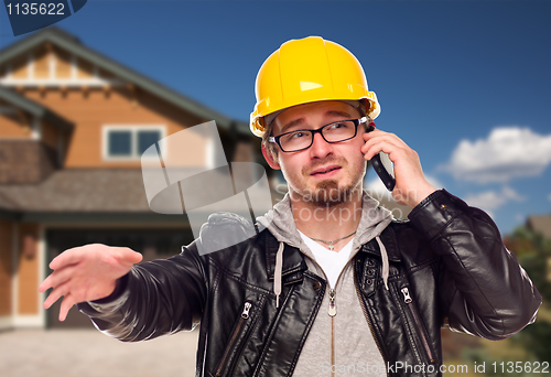 Image of Contractor Wearing Hard Hat on Phone In Front of House