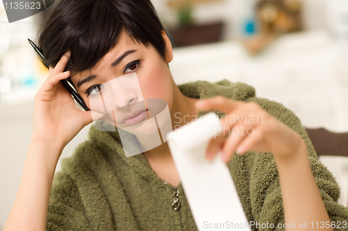 Image of Multi-ethnic Young Woman Agonizing Over Financial Calculations