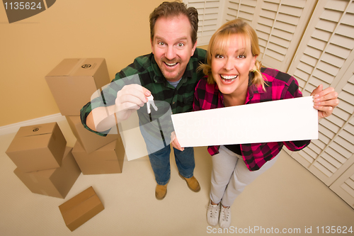 Image of Goofy Couple Holding Keys and Blank Sign Surrounded by Boxes