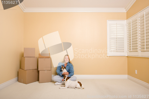 Image of Pretty Woman and Dogs with Moving Boxes in Room on Floor