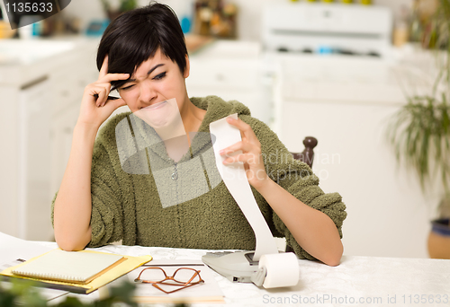 Image of Multi-ethnic Young Woman Agonizing Over Financial Calculations