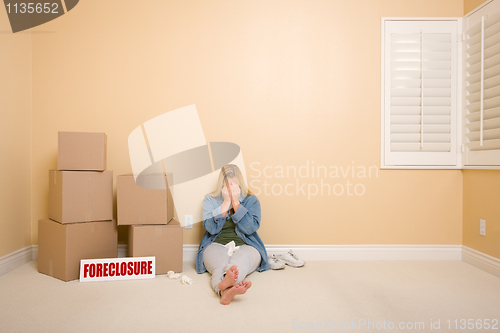 Image of Upset Woman on Floor Next to Boxes and Foreclosure Sign