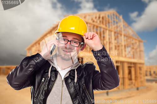 Image of Young Cunstruction Worker on Cell Phone In Front of House