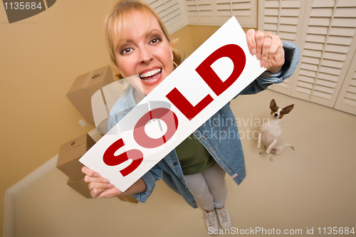 Image of Woman and Doggy with Sold Sign Near Moving Boxes