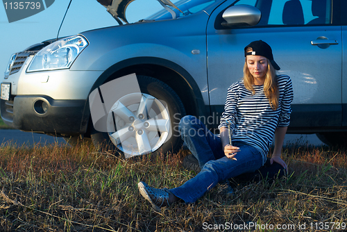 Image of Young Blond Woman With Her Broken Car