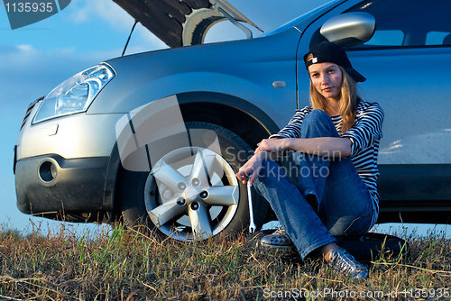 Image of Young Blond Woman With Her Broken Car