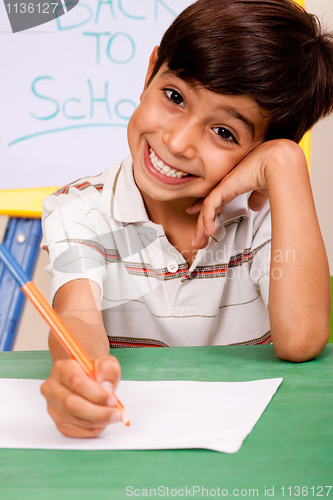 Image of Portrait of cheerful boy writing notes