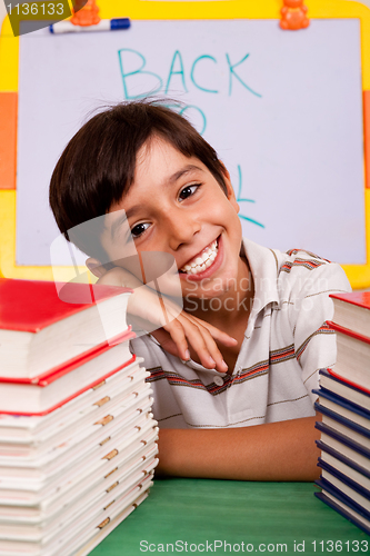 Image of Young boy with stack of books