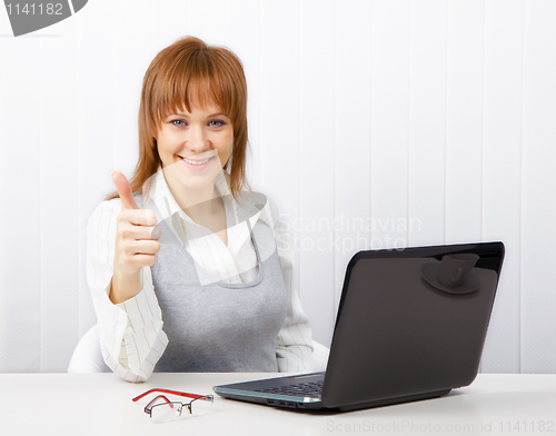 Image of attractive girl with a thumb up in the office