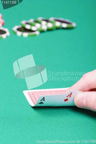 Image of poker player with two aces