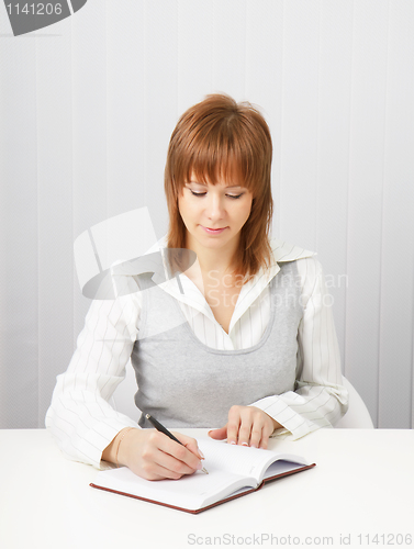 Image of business attractive girl with a notebook and pen.