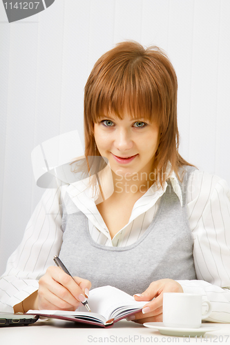 Image of smiling girl with a notebook