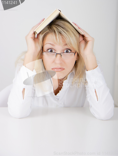 Image of girl in glasses hidden under a book