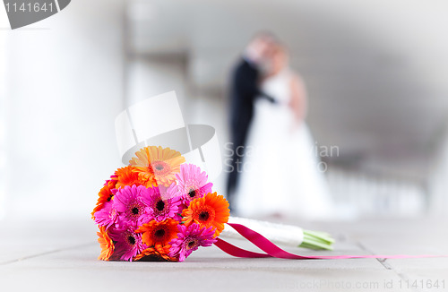 Image of Bride and groom with weddings bouquet in front