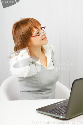 Image of tired girl with a laptop stretches