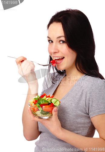 Image of Young attractive woman eats vegetable salad