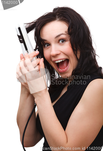 Image of Woman is screaming while using hair straightener