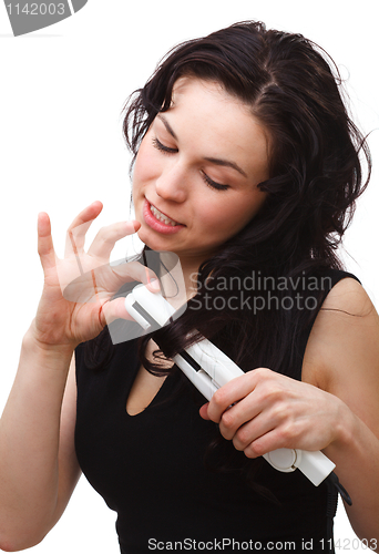 Image of Woman is using hair straightener