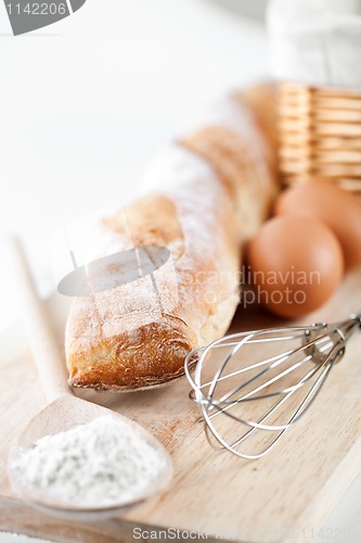 Image of still life of bread, flour, eggs and kitchen utensil