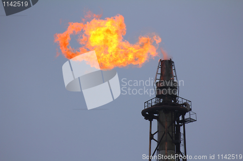 Image of torch is lit on tower refinery