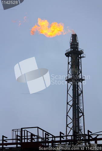 Image of torch is lit on tower refinery