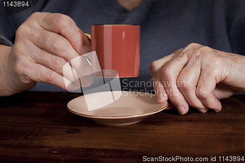 Image of old hands and coffee cup
