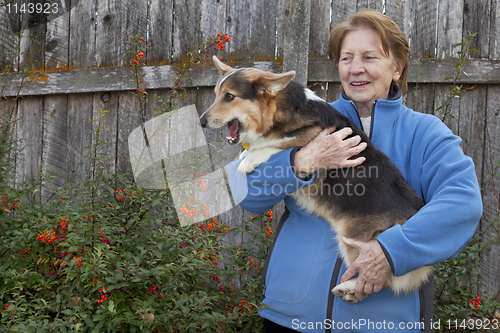 Image of old woman with corgi puppy