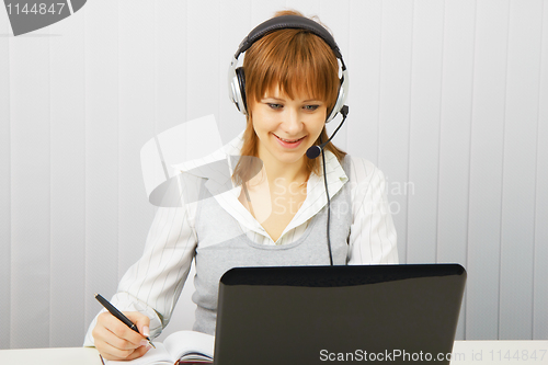 Image of Attractive girl in a white blouse with a laptop