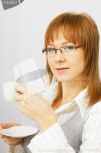 Image of attractive girl in the office with a cup of coffee