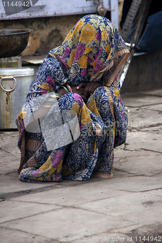 Image of Terrified woman hiding under cover from punishment.