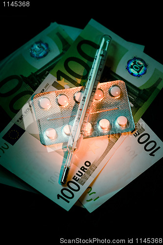 Image of Banknotes with pills blister and thermometer