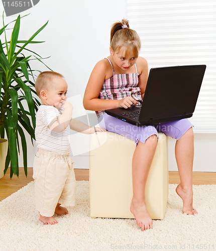 Image of Sister and brother with computer