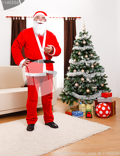 Image of Santa Claus standing in front of Christmas Tree
