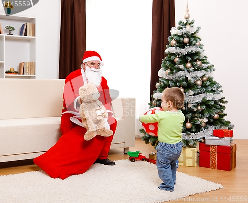 Image of Santa Claus showing toy from bag