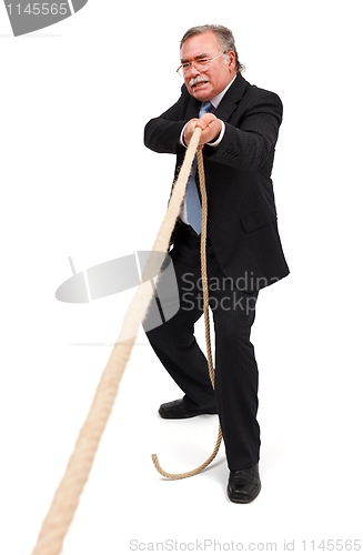 Image of Senior business man pulling the rope hard