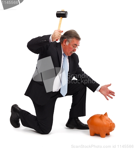 Image of Business man breaking piggy bank