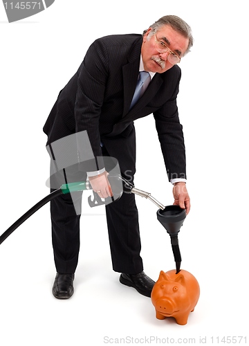 Image of Business man filling gas in piggy bank