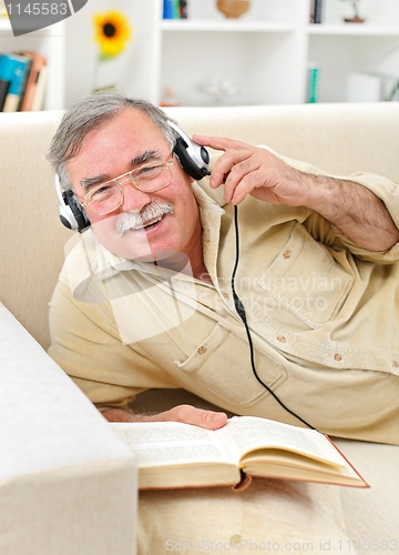 Image of Happy senior man listening to music