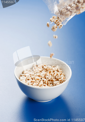 Image of Popped wheat flakes pouring in plate