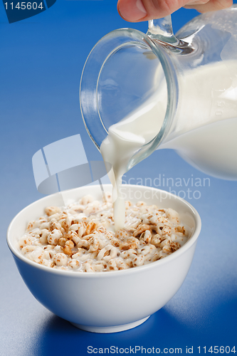 Image of Pouring milk over wheat popped flakes