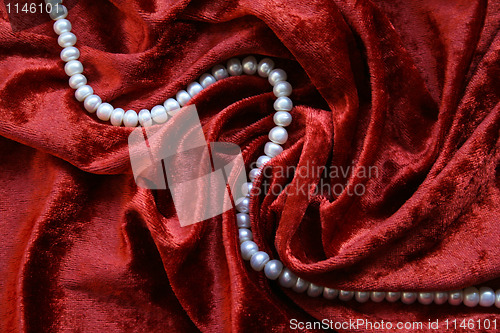 Image of Necklace of white pearls on a terracotta velvet background 