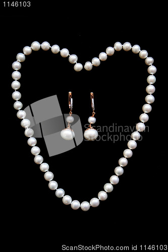 Image of  Necklace of white pearls and golden earrings with diamonds on t