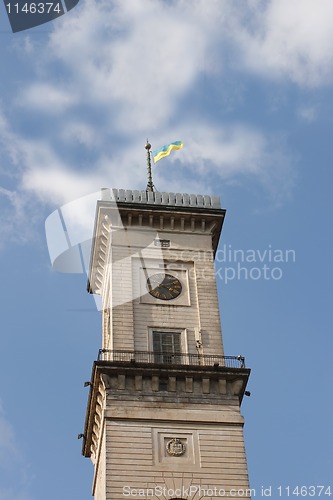 Image of Clock tower against blue sky with clouds